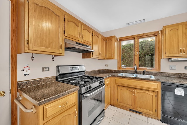 kitchen with dishwasher, sink, gas range, dark stone countertops, and light tile patterned flooring