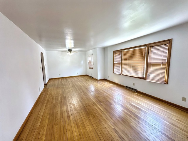 665 W Blue St, Sheldon, IL 60966 - spare room featuring arched walkways, a ceiling fan, and light wood finished floors