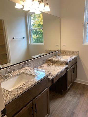 bathroom featuring vanity, hardwood / wood-style flooring, and an inviting chandelier