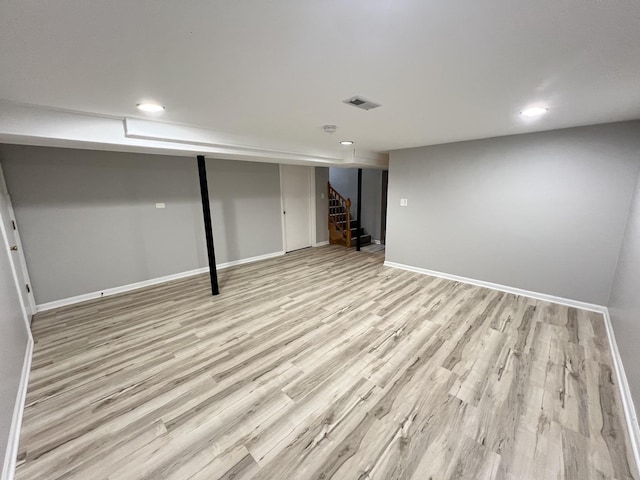 basement with light hardwood / wood-style flooring