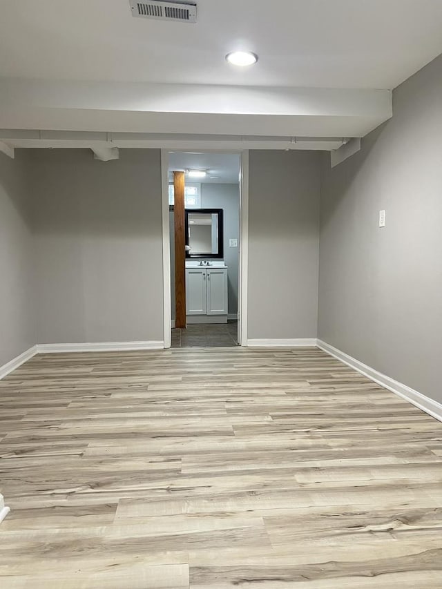 basement with light hardwood / wood-style floors