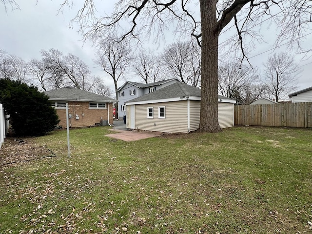 rear view of house featuring a patio area, a yard, and central AC