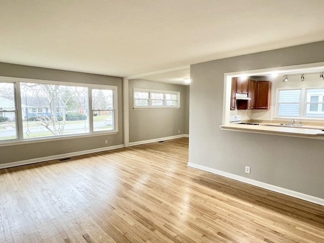 unfurnished living room featuring light hardwood / wood-style flooring and sink