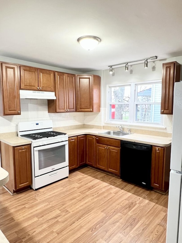 kitchen with white appliances, light hardwood / wood-style floors, backsplash, and sink