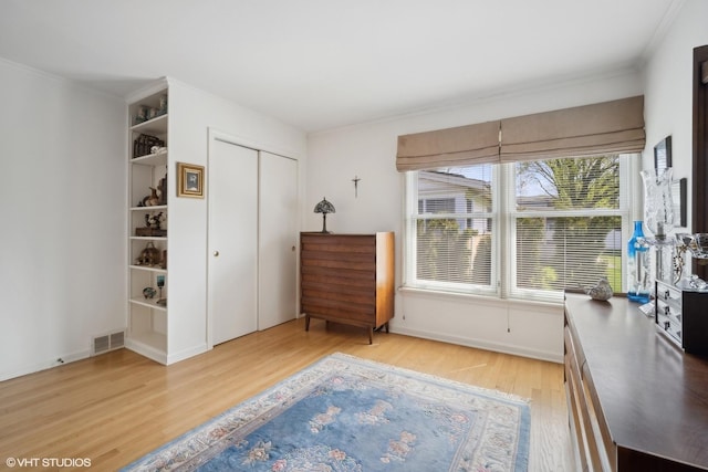 living area with light wood-type flooring and crown molding