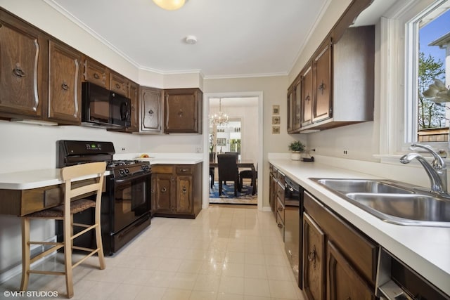 kitchen featuring dark brown cabinets, sink, black appliances, and plenty of natural light