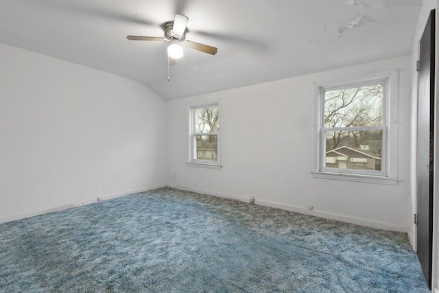 carpeted empty room with ceiling fan, lofted ceiling, and a wealth of natural light