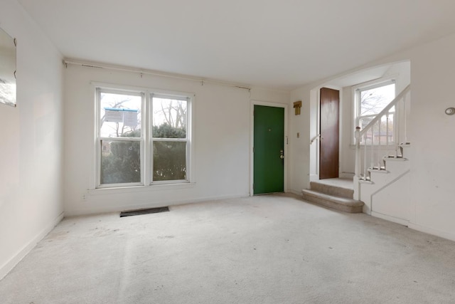 unfurnished room featuring light carpet