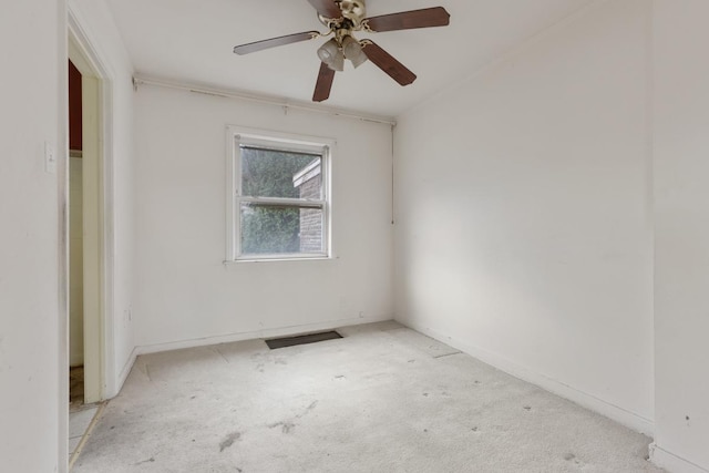 spare room with ceiling fan and light carpet