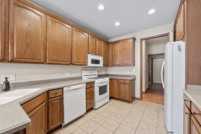 kitchen featuring light tile patterned floors, sink, and white appliances