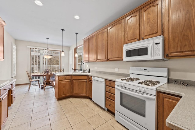 kitchen with pendant lighting, kitchen peninsula, sink, white appliances, and light tile patterned floors