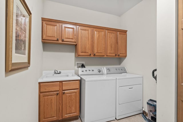 washroom featuring light tile patterned floors, independent washer and dryer, sink, and cabinets