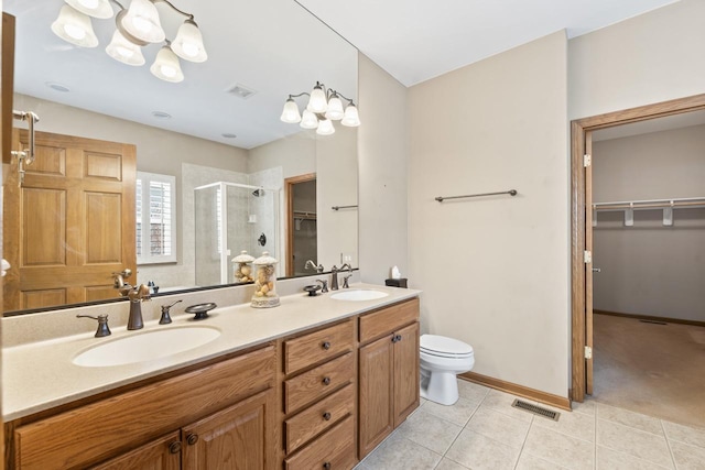 bathroom featuring vanity, toilet, tile patterned floors, and a shower with door