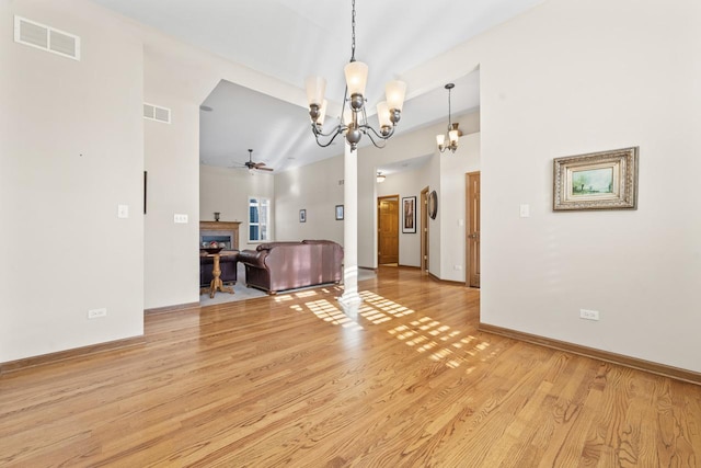 interior space featuring ceiling fan with notable chandelier and light hardwood / wood-style floors