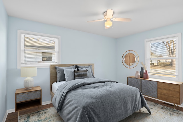 bedroom with multiple windows, hardwood / wood-style floors, and ceiling fan