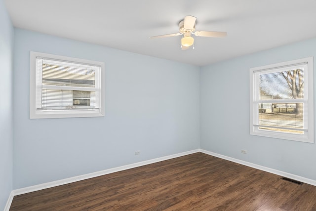 spare room featuring dark wood-type flooring and ceiling fan