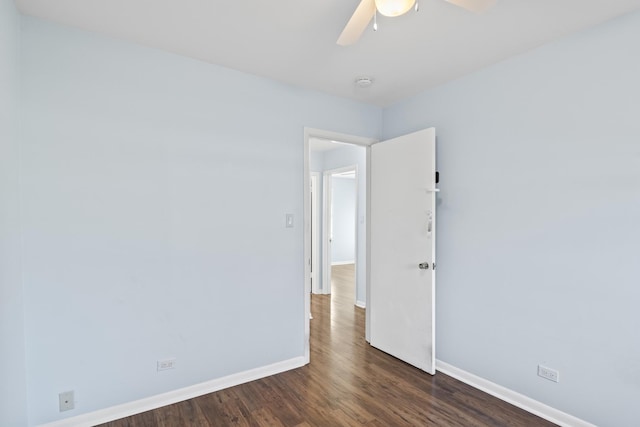 empty room featuring dark wood-type flooring and ceiling fan