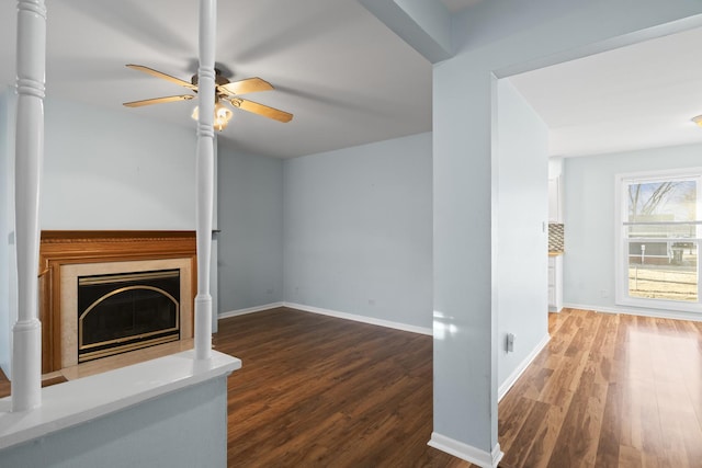 unfurnished living room with ceiling fan, dark wood-type flooring, and a high end fireplace