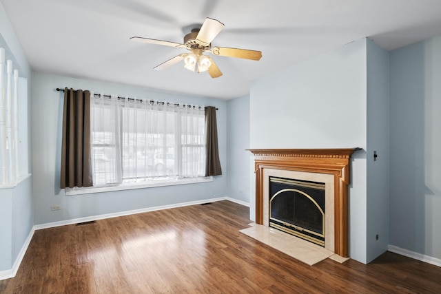 unfurnished living room featuring dark wood-type flooring and ceiling fan