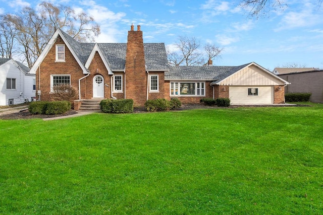 tudor home featuring a front lawn, a chimney, and brick siding