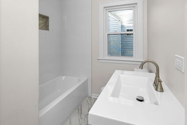 bathroom with marble finish floor, baseboards, and a sink