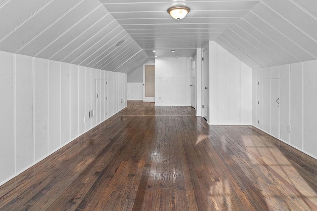 additional living space featuring lofted ceiling and dark wood-type flooring