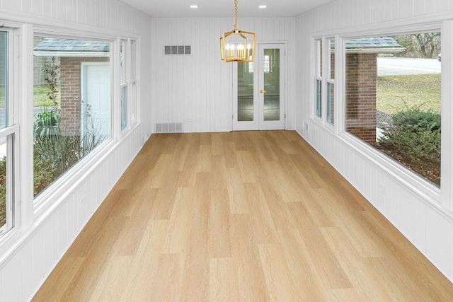 unfurnished sunroom with visible vents and a notable chandelier