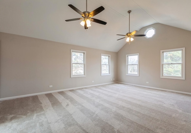 empty room featuring light colored carpet, plenty of natural light, lofted ceiling, and ceiling fan