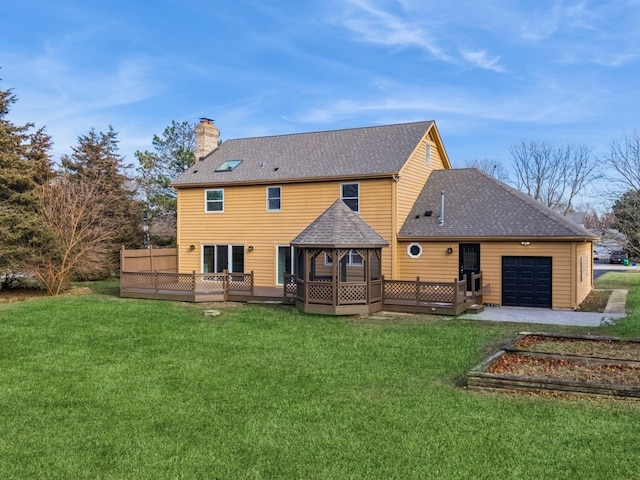 back of house with a gazebo, a garage, a deck, and a yard