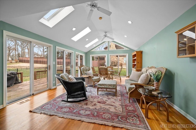 interior space with ceiling fan, vaulted ceiling, and light wood-type flooring