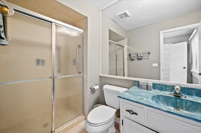 bathroom with vanity, toilet, a shower with shower door, and tile patterned flooring