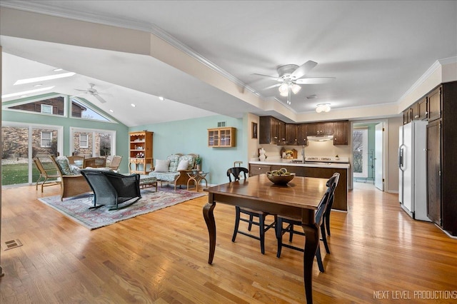 dining area with lofted ceiling, a wealth of natural light, light hardwood / wood-style floors, and ceiling fan