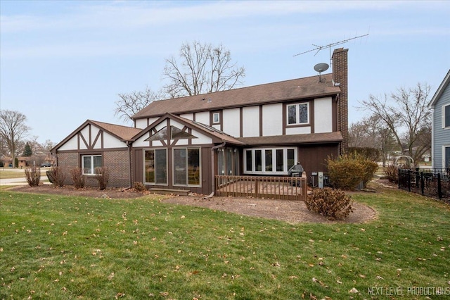 rear view of property featuring a lawn and a deck