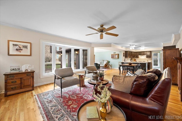 living room featuring crown molding, light hardwood / wood-style floors, and ceiling fan