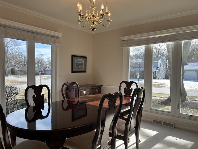 dining space with a notable chandelier, carpet floors, and ornamental molding