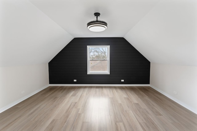 additional living space with light hardwood / wood-style floors and lofted ceiling