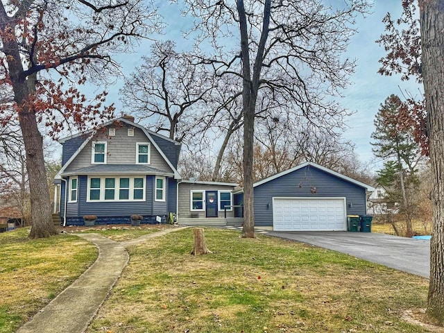 dutch colonial featuring a shingled roof, a gambrel roof, a chimney, a detached garage, and a front yard