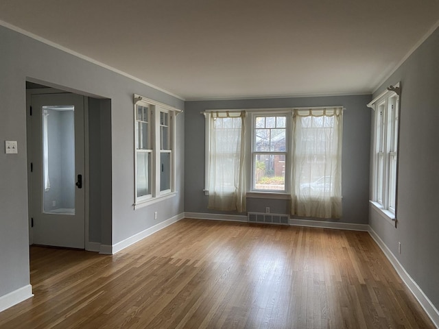 unfurnished room featuring hardwood / wood-style floors and crown molding