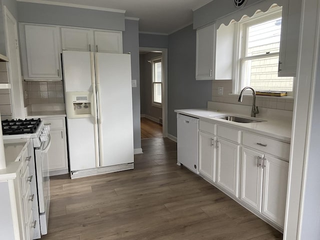 kitchen featuring white appliances, white cabinets, sink, tasteful backsplash, and light hardwood / wood-style floors