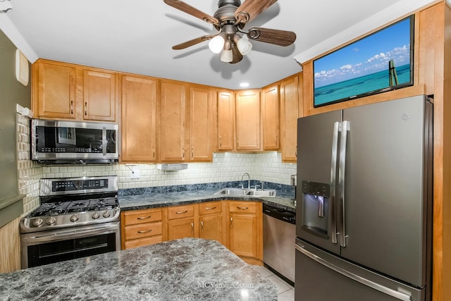 kitchen with dark stone counters, sink, ceiling fan, tasteful backsplash, and stainless steel appliances