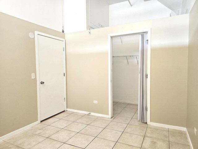 unfurnished bedroom featuring light tile patterned floors and a closet