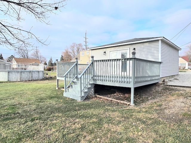 rear view of property with a wooden deck and a yard