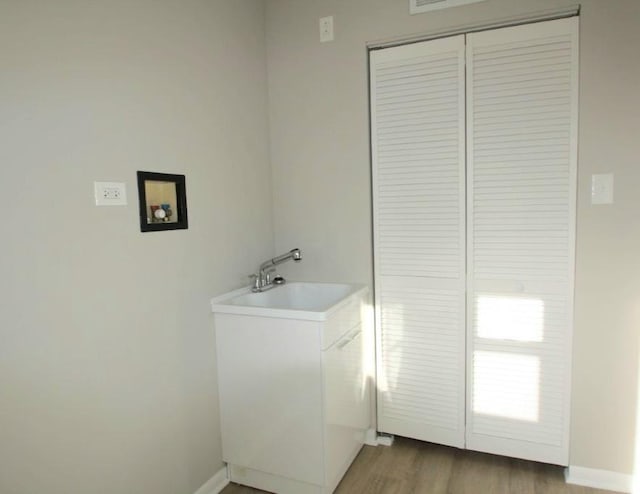 washroom featuring hardwood / wood-style flooring, washer hookup, and sink