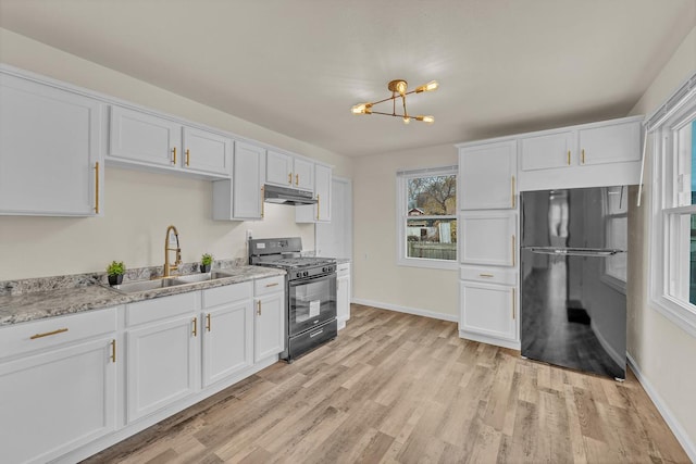 kitchen featuring sink, white cabinets, black appliances, and light wood-type flooring