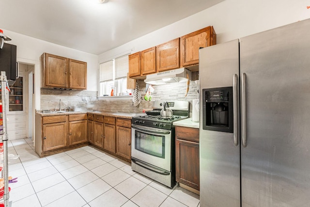 kitchen with appliances with stainless steel finishes, sink, tasteful backsplash, and light tile patterned flooring