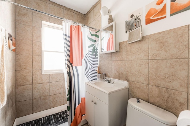 bathroom with walk in shower, vanity, a wealth of natural light, and tile walls