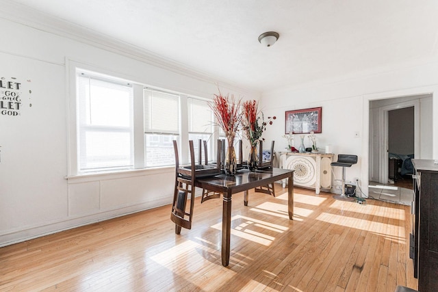 dining space with crown molding and hardwood / wood-style flooring