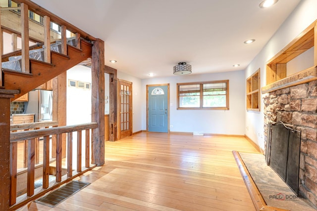 interior space featuring light hardwood / wood-style floors and a stone fireplace