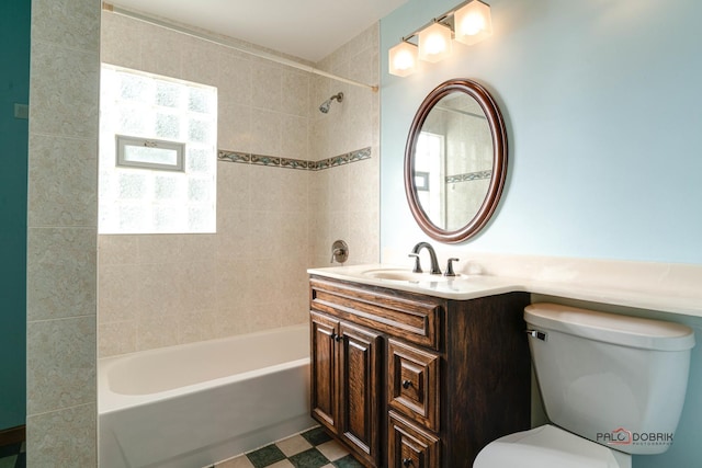 full bathroom with vanity, tiled shower / bath combo, and toilet