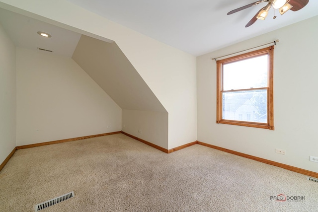 additional living space with ceiling fan, light colored carpet, and vaulted ceiling